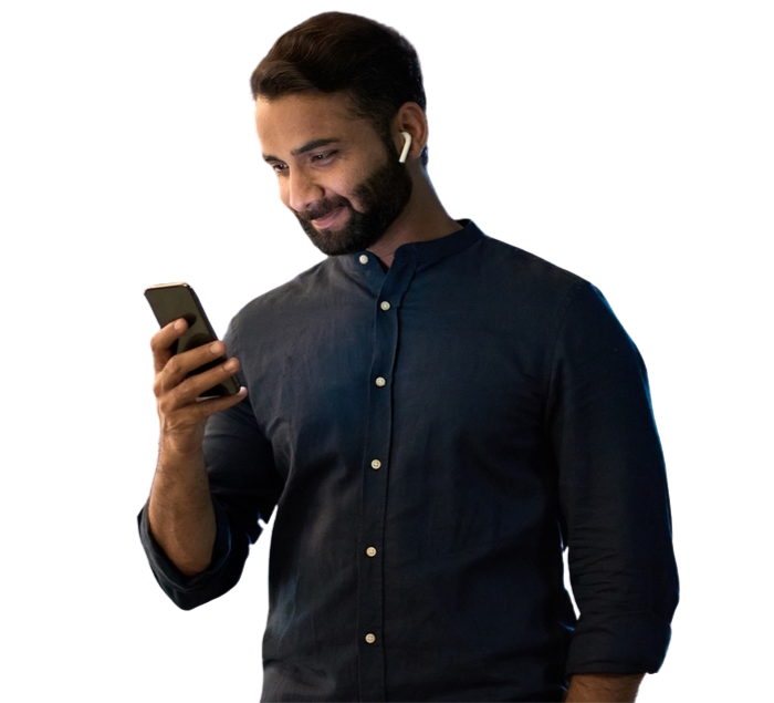 A bearded man is holding a cell phone, looking intently at the screen with a focused expression.